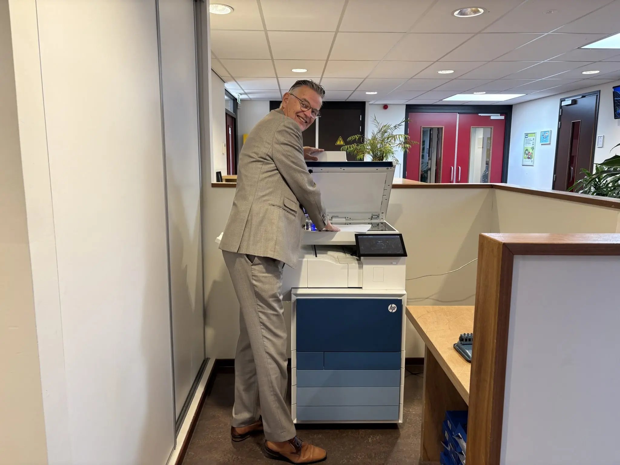 Directeur-van-de-J.H.-Donnerschool-bij-printer-–-voorbeeld-van-veilig-printen-in-het-speciaal-onderwijs-met-Avictus-2048x1536